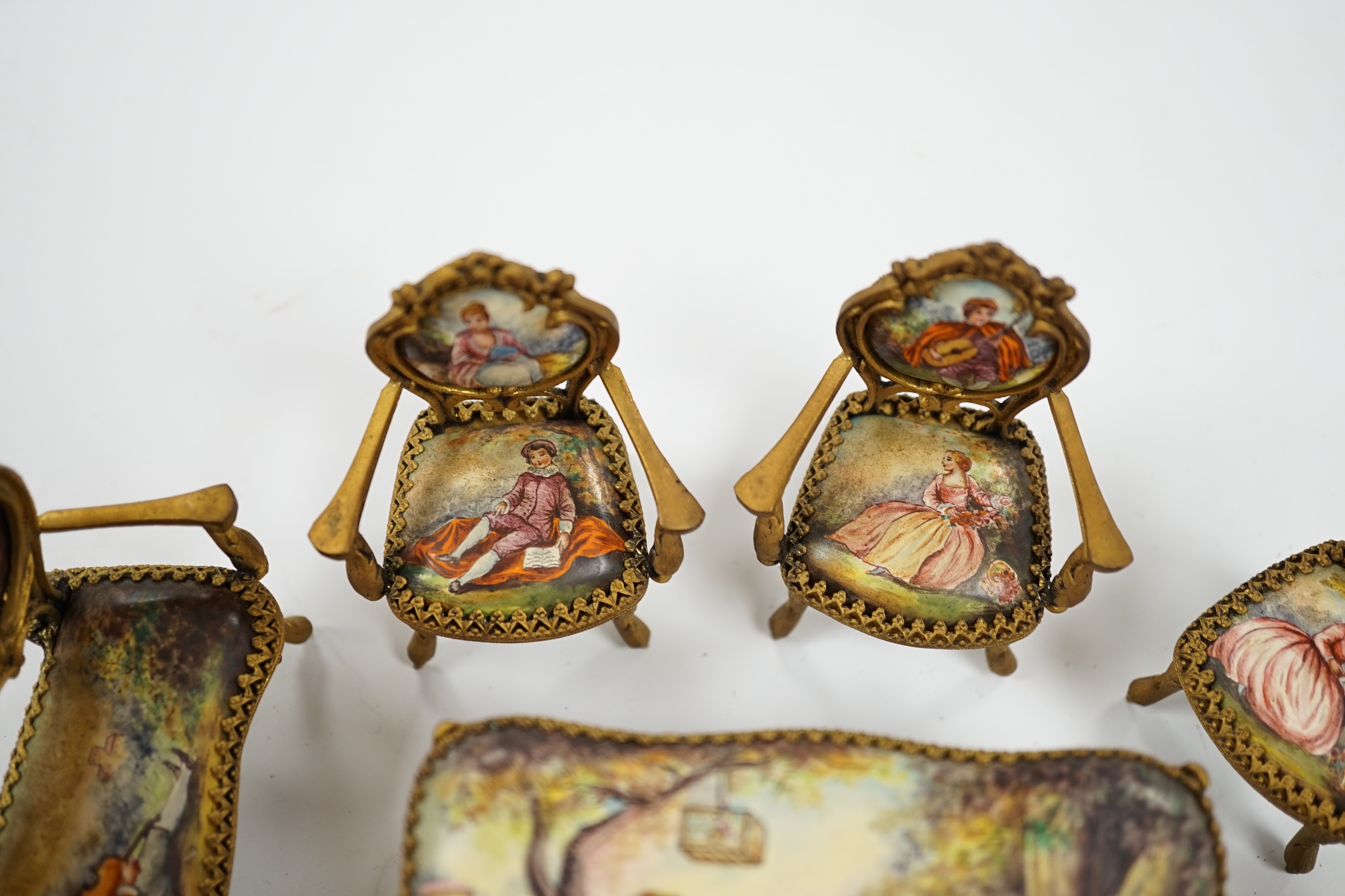 An early 20th century miniature enamel and gilt metal framed furniture set, possibly Austrian, largest 9cm wide. Condition - fair